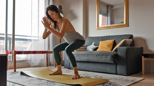 Slim Woman Doing Yoga In Living Room