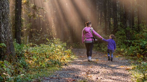 Mom and daughter walking in the woods