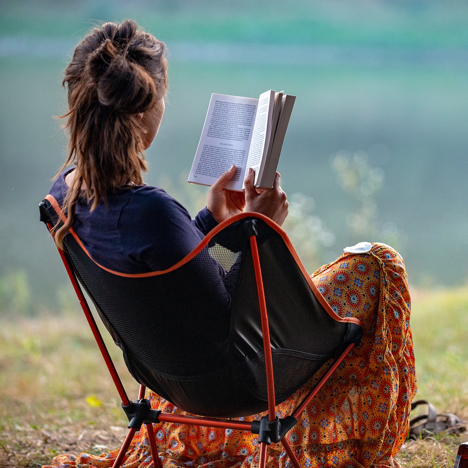 girl reads a book by the river. Ukraine. Chernihiv.