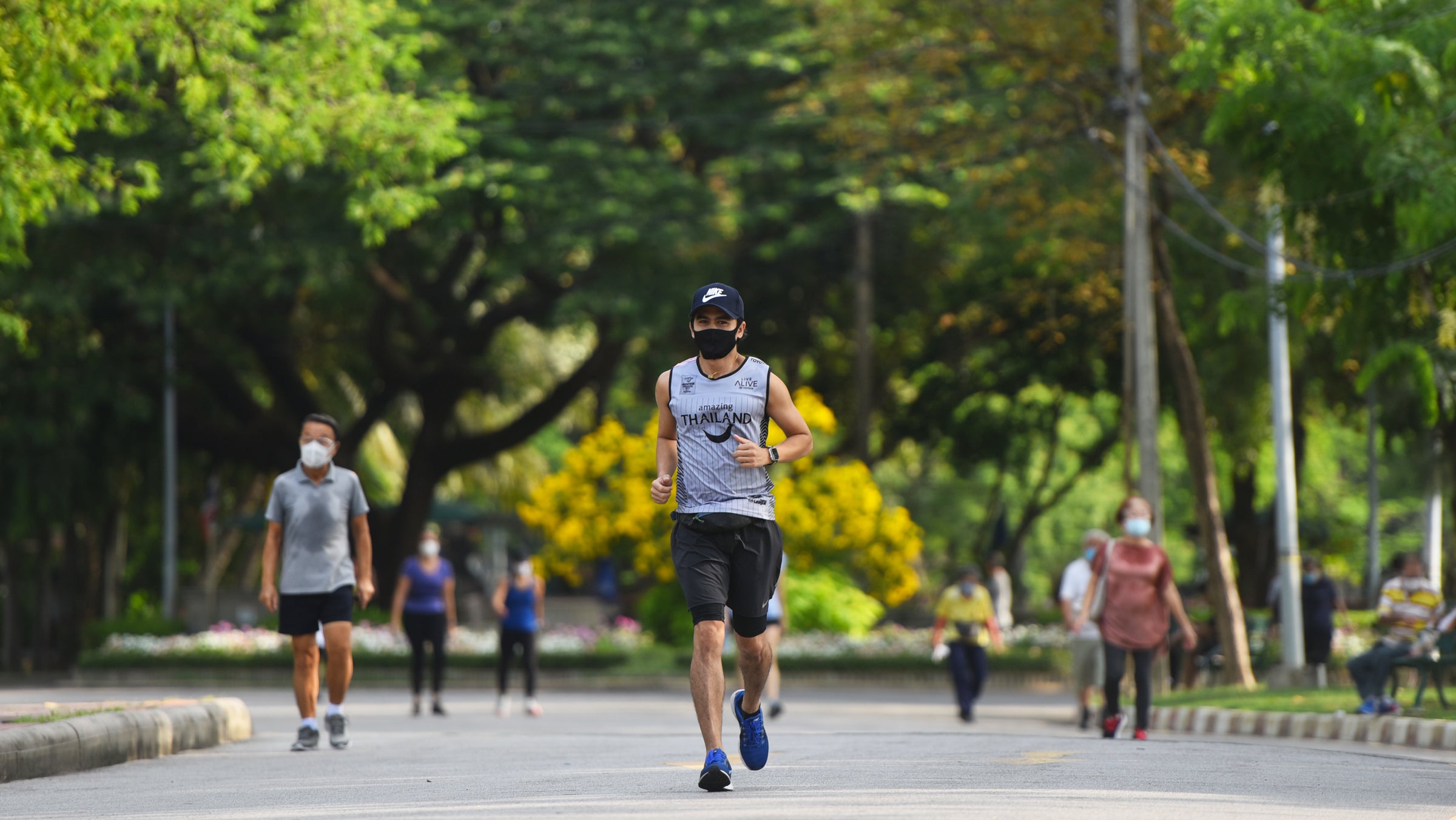 A man is seen running while wearing a face mask as a