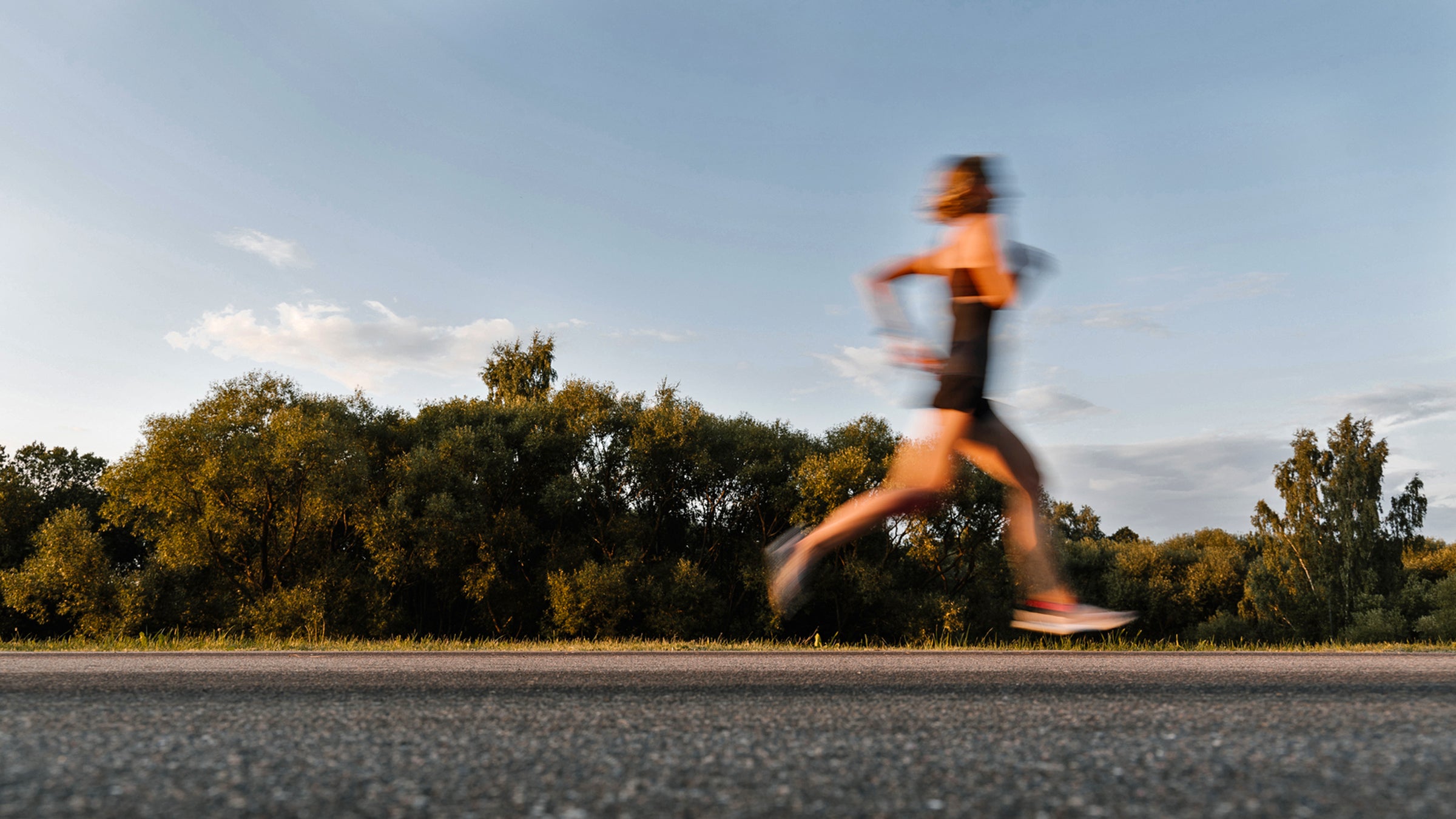 Beautiful Woman Running On The Road With Motion Blur