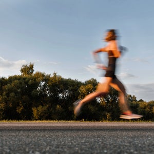 Beautiful Woman Running On The Road With Motion Blur