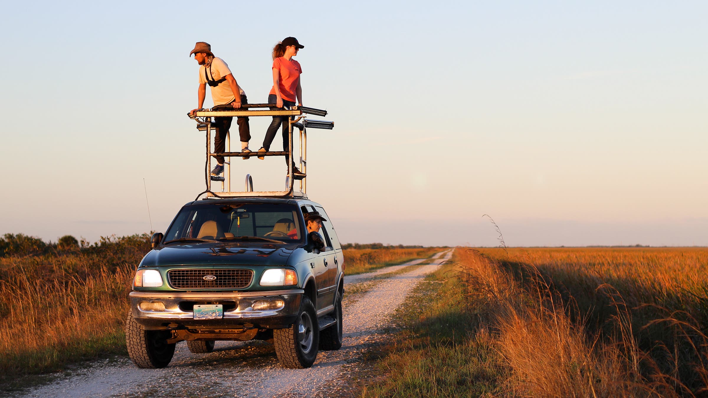 Professional python hunter Donna Kalil drives along a levee while her daughter, Deanna, and Kevin Pavlidis, a family friend, look for snakes from the perch atop Kalil’s SUV.