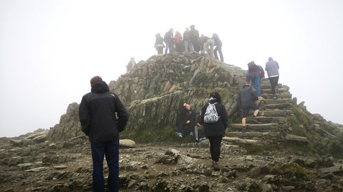 Mount Snowdon with climbers scaling the last few steps to the summit.