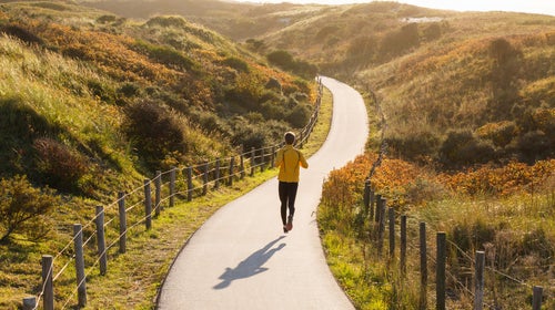 Young Caucasian Man Running In The Dunes During Sunset.