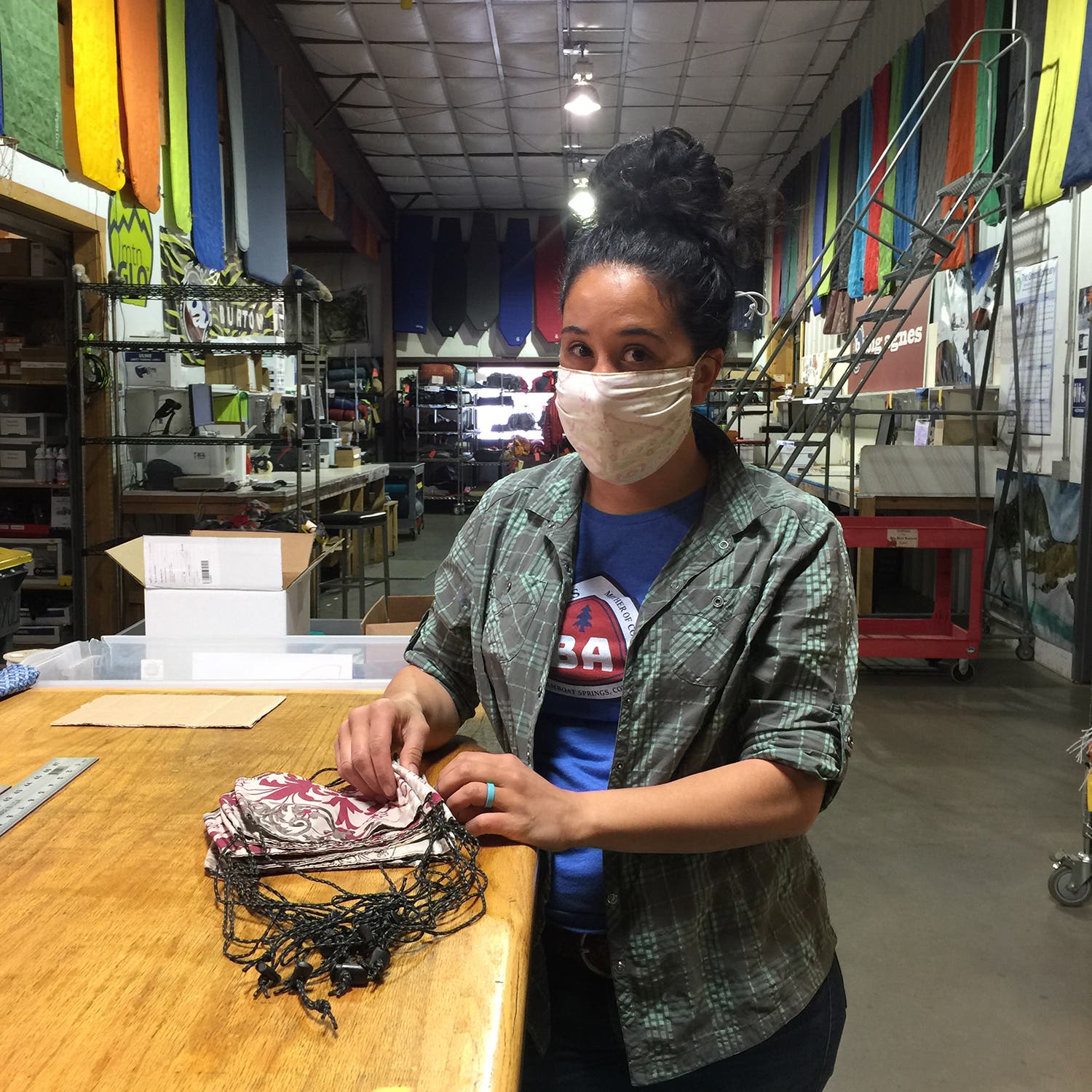 woman wearing face mask touching a pile of face masks