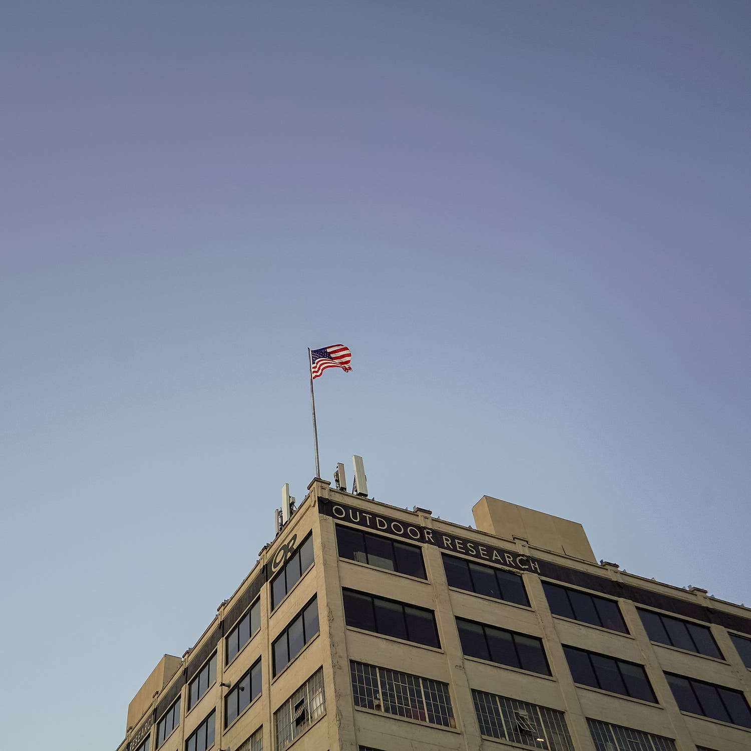 top of building with many windows with an american flag flying at the top