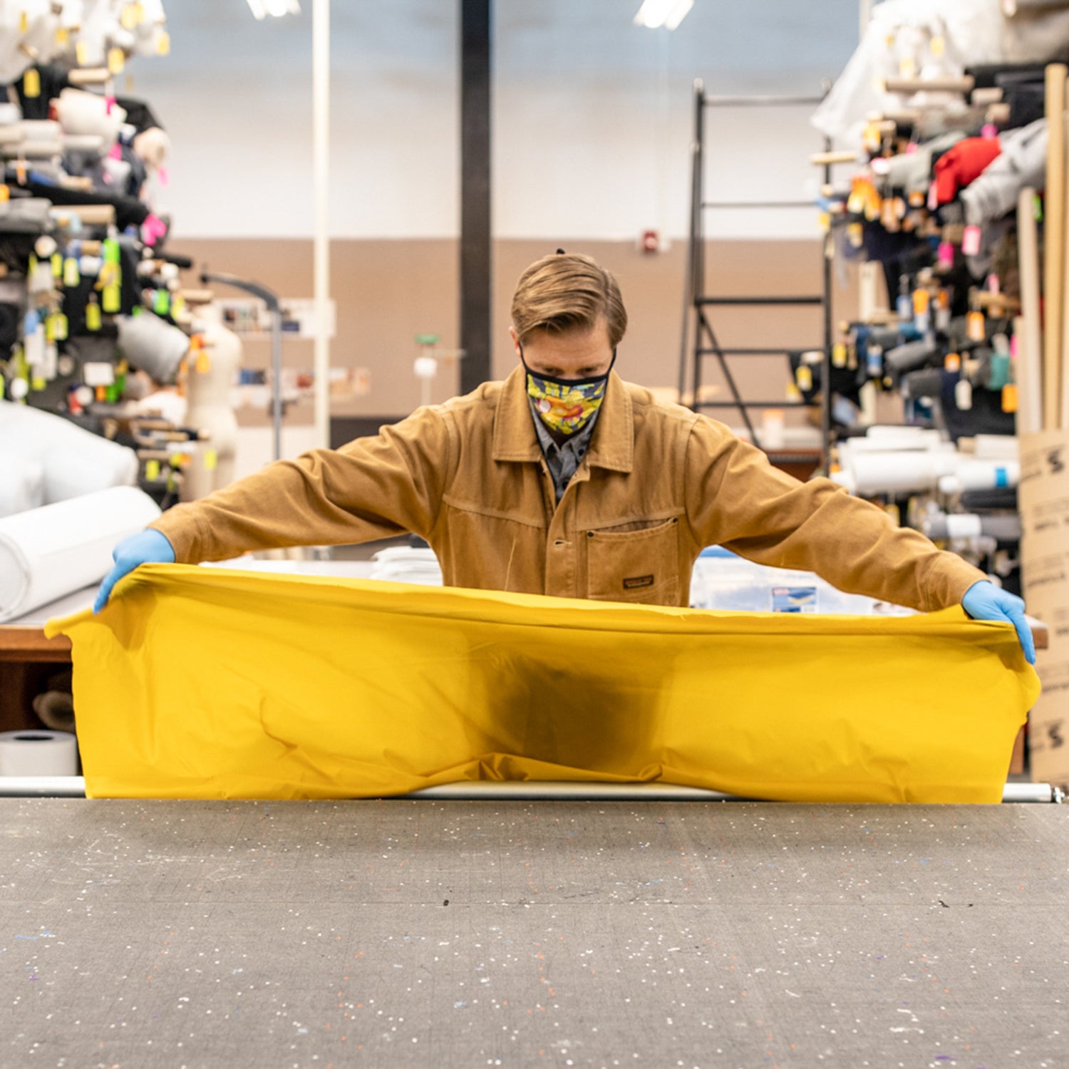man wearing face mask stretching yellow fabric