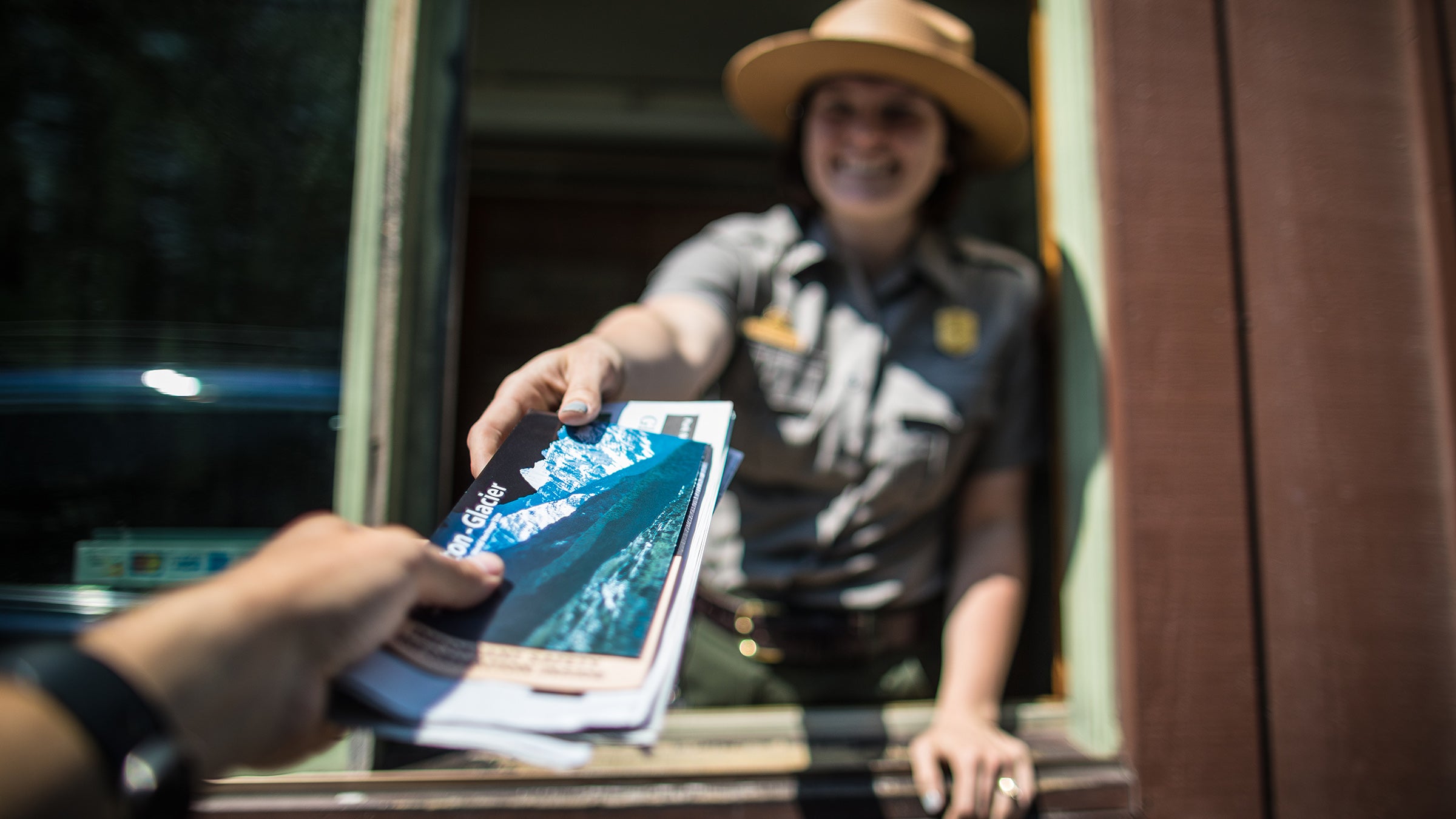 A ranger greets a visitor at Glacier National Park in 2018. 