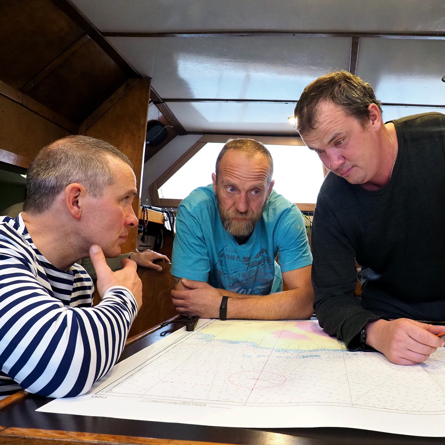 Alexander Bogdanov (left), Andrey Ianushkevich (center), and Mikhail Tekuchev (right) discuss the expedition route.