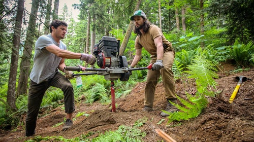 Bryan and Pat use an auger to dig holes for support piers.
