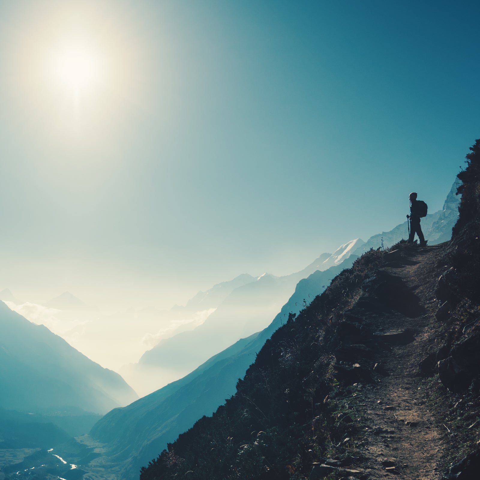 Standing woman on the hill against mountain valley at bright sunny day. Landscape with girl, trail, mountain, blue sky with sun and low clouds at sunset in Nepal.  Lifestyle, travel. Trekking