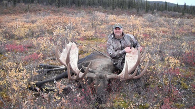 Interior secretary David Bernhardt posing with a dead moose