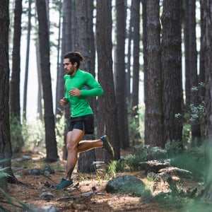 Fit Active Man Running A Trail Through A Forest