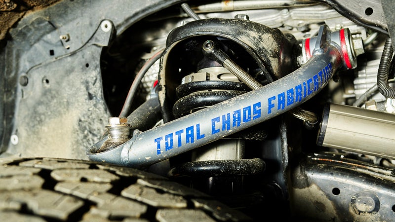 A peek behind the Land Cruiser’s front wheel offers a hint at how special its suspension system is. The Total Chaos upper control arms facilitate additional drop travel using a high-angle uniball that can achieve a steeper angle to the spindle than stock items. Both the ball and its race are made from heat-treated stainless steel for corrosion resistance, while a PTFE fabric liner between the two helps prevent noise. Urethane bushings prevent sideways deflection of the arm better than rubber stock bushings, helping align of the rest of the suspension system’s higher-performance components and increasing durability during more extreme use. Zerk fittings facilitate easy lubrication of those bushings.
