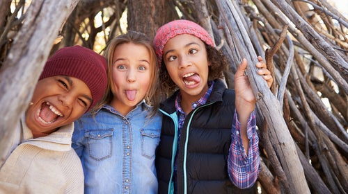 Group Of Children Playing In Forest Camp Together