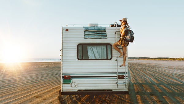 Young girl climbing the top of motorhome