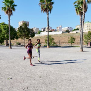 Two Women Jogging Through A Park