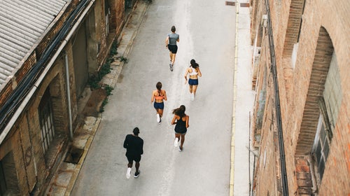 Group Of Athletes Running On The Street From Above.