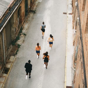 Group Of Athletes Running On The Street From Above.