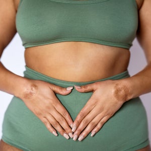 Midsection shot of a woman in underwear on white background.