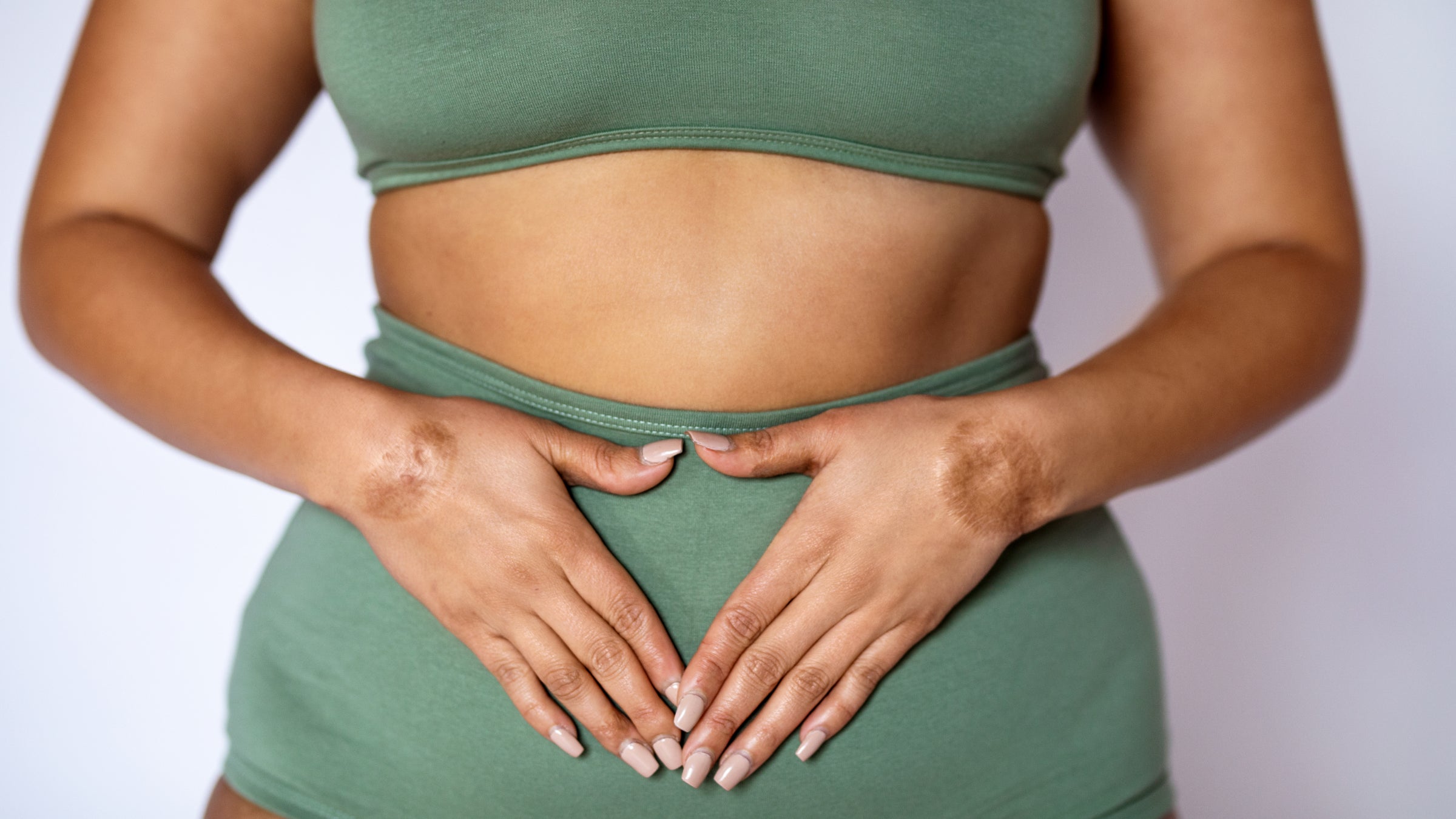 Midsection shot of a woman in underwear on white background.