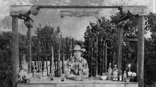 I constructed a ten-by-six-foot L-shaped structure, bracketed by three posts crowned with old wood corbels—decorative supports—that I found in the junk pile.