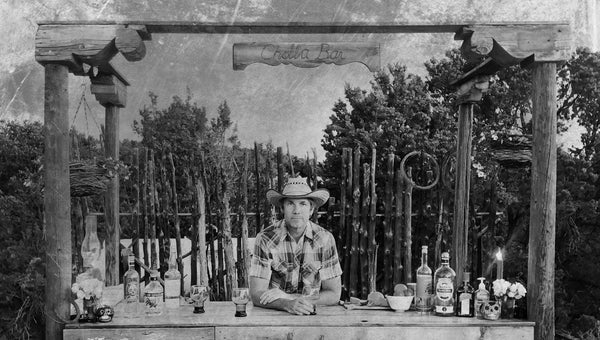 I constructed a ten-by-six-foot L-shaped structure, bracketed by three posts crowned with old wood corbels—decorative supports—that I found in the junk pile.
