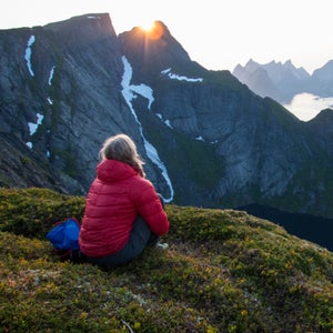 Hilary Oliver looks out over the fjords and peaks near Reine, Norway, from the top of Reinebringen.
