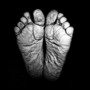 A black and white photo of the bottom of wrinkled feet