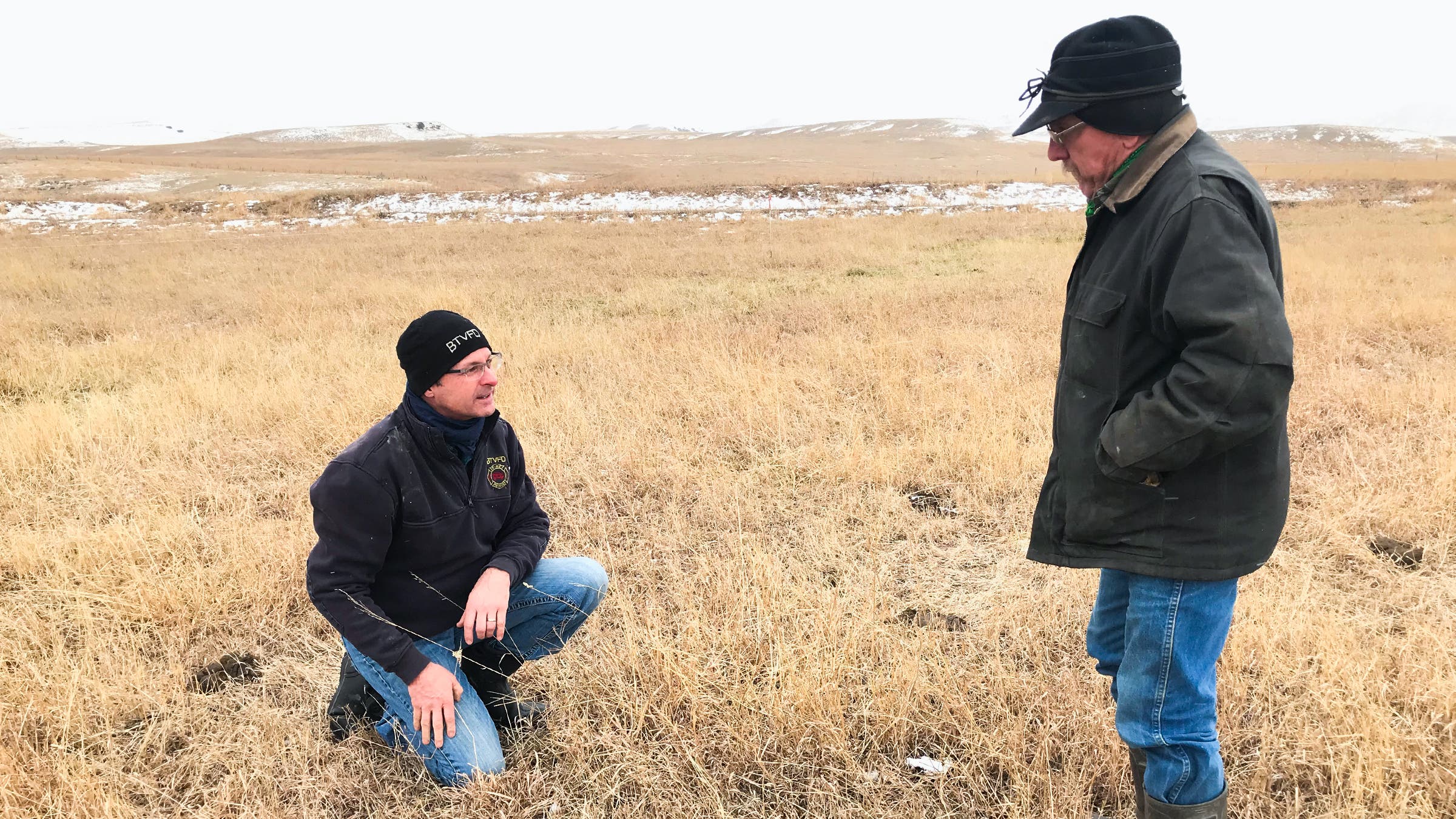 Chris Mehus, left, program director for the Western Sustainability Exchange, and Roger Indreland looking at grass regrowth on Indreland’s ranch