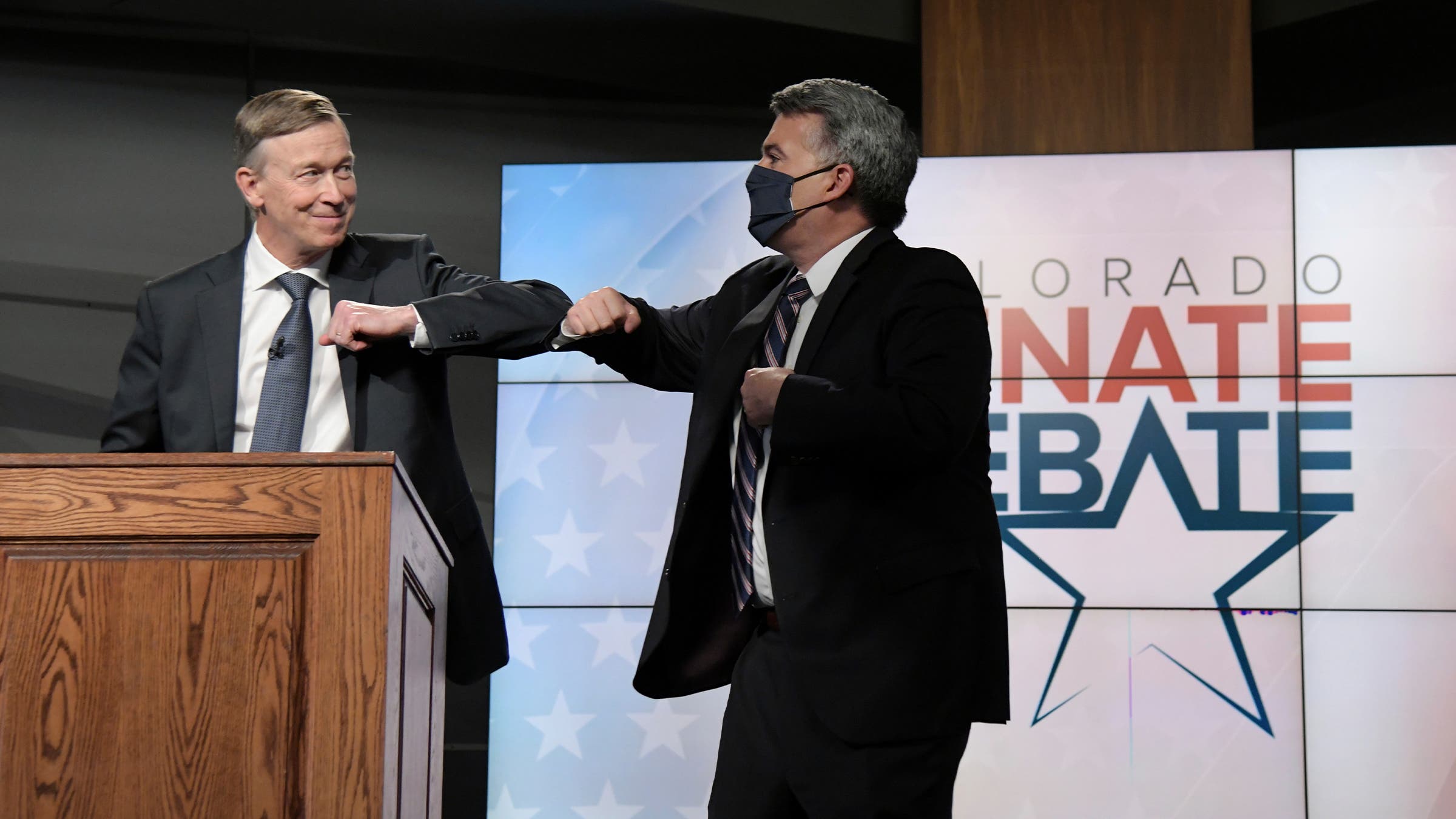 Republican senator Cory Gardner, right, and Democratic former Colorado governor John Hickenlooper elbow-bump after a debate on October 9, 2020.