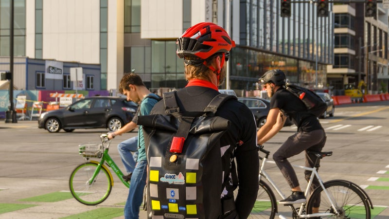 SEATTLE, WASHINGTON STATE, USA - JUNE 2018: Cyclist commuting to work in Seattle waiting at a road junction.