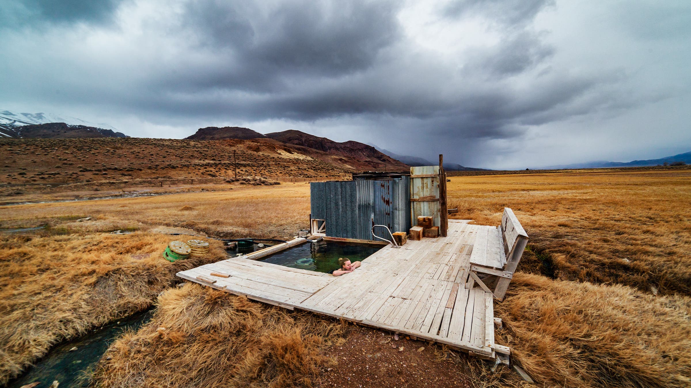 A storm blows over the mountains behind a spring in Oregon