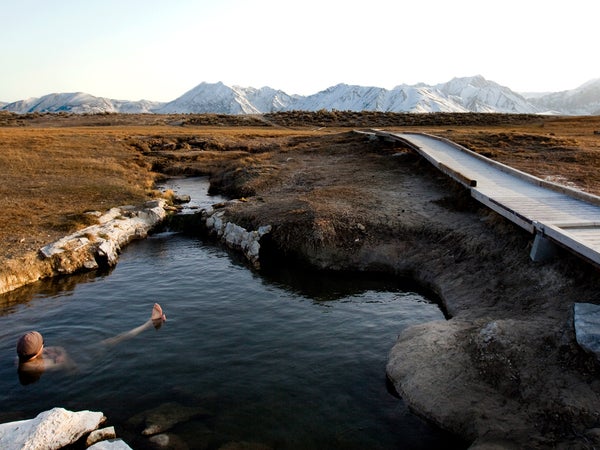 A man enjoys a hot spring near the mountains in California.