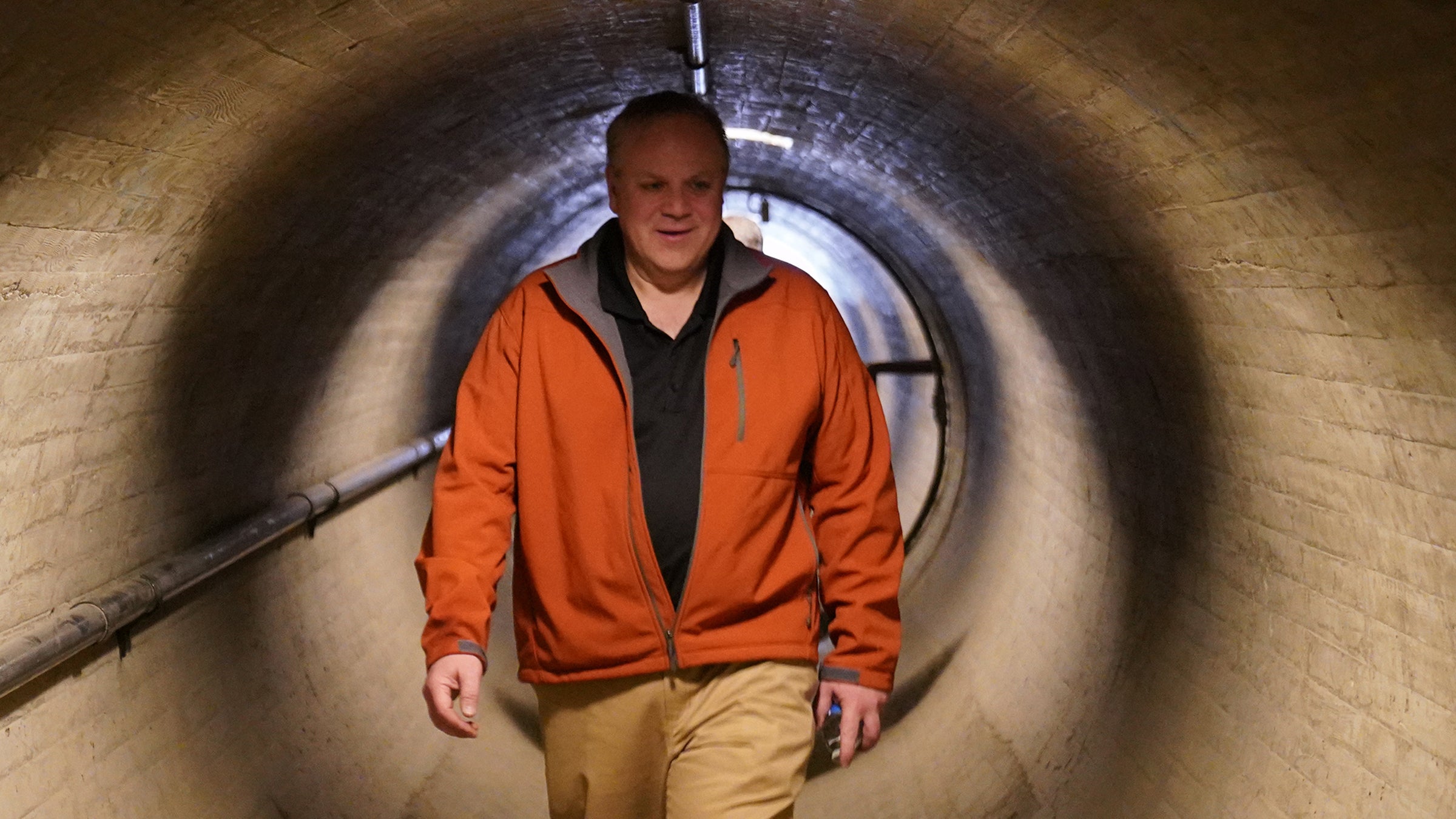 Secretary of the Interior, oil lobbyist David Bernhardt, walks through a tunnel. 