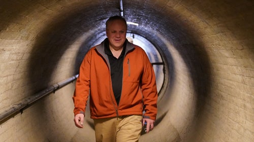 Secretary of the Interior, oil lobbyist David Bernhardt, walks through a tunnel.
