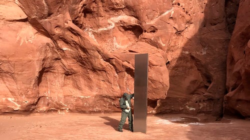 A Utah state worker inspecting a metal monolith