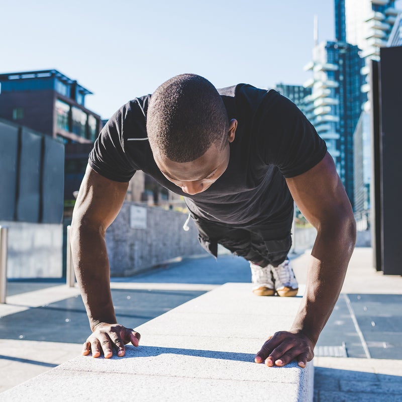 Young man exercising outdoors, doing push-ups