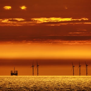 Offshore windmills alongside an oil rig