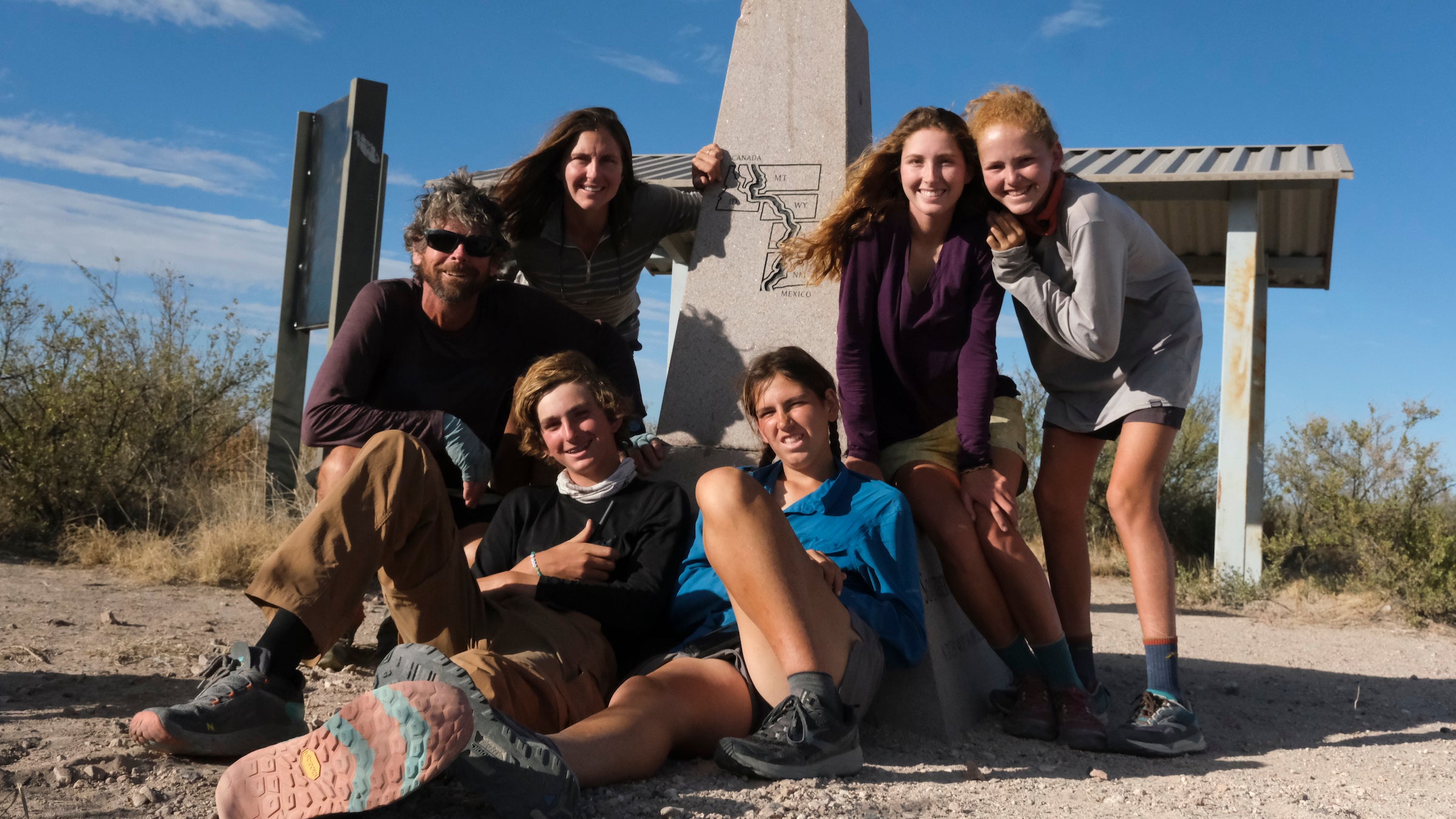 Clockwise from left: Vince, Monica, Aiden, Georgie, June, and Henry at Crazy Cook Monument after completing their southbound CDT hike