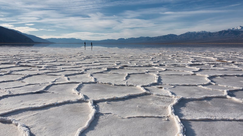 Badwater salt polygons in morning light with silhouette two people