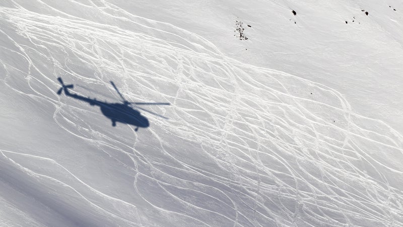 Shadow from helicopter on snowy off-piste ski slope