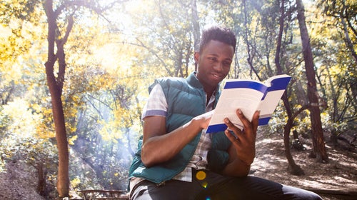 Young male hiker reading guidebook in forest, Arcadia, California, USA