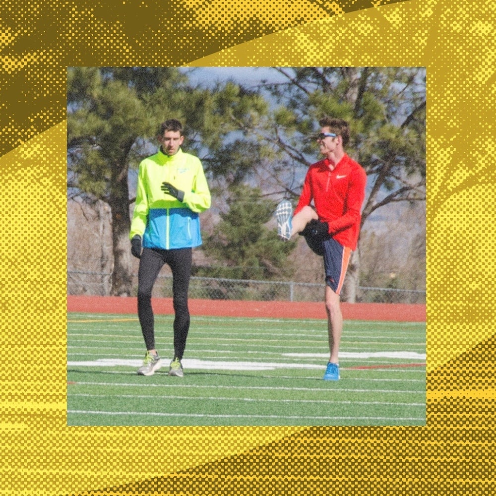 Two professional runners warm up on the grass