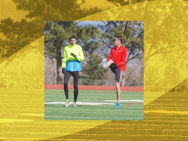 Two professional runners warm up on the grass