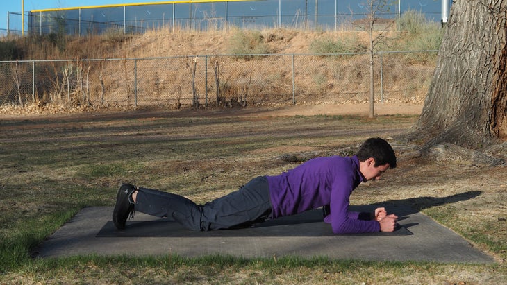 a man in a plank on his knees and elbows in a purple shirt