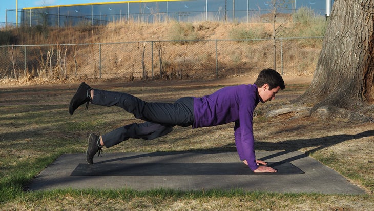 man in high plank with right leg raised backward