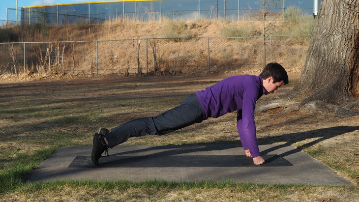 man in high plank on fists