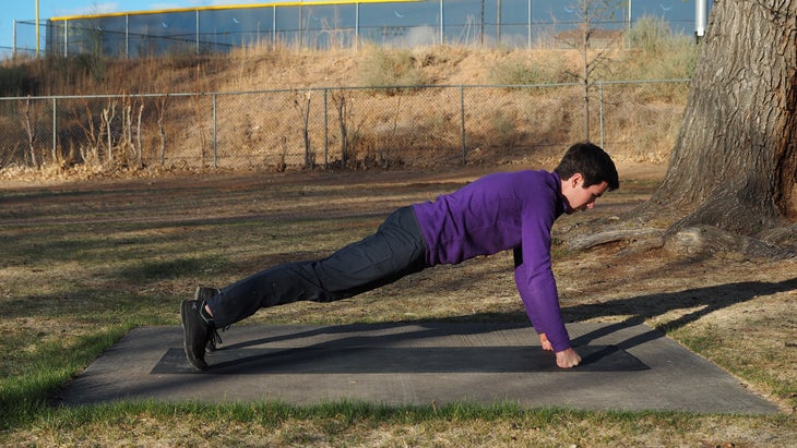 man in purple in high fist plank